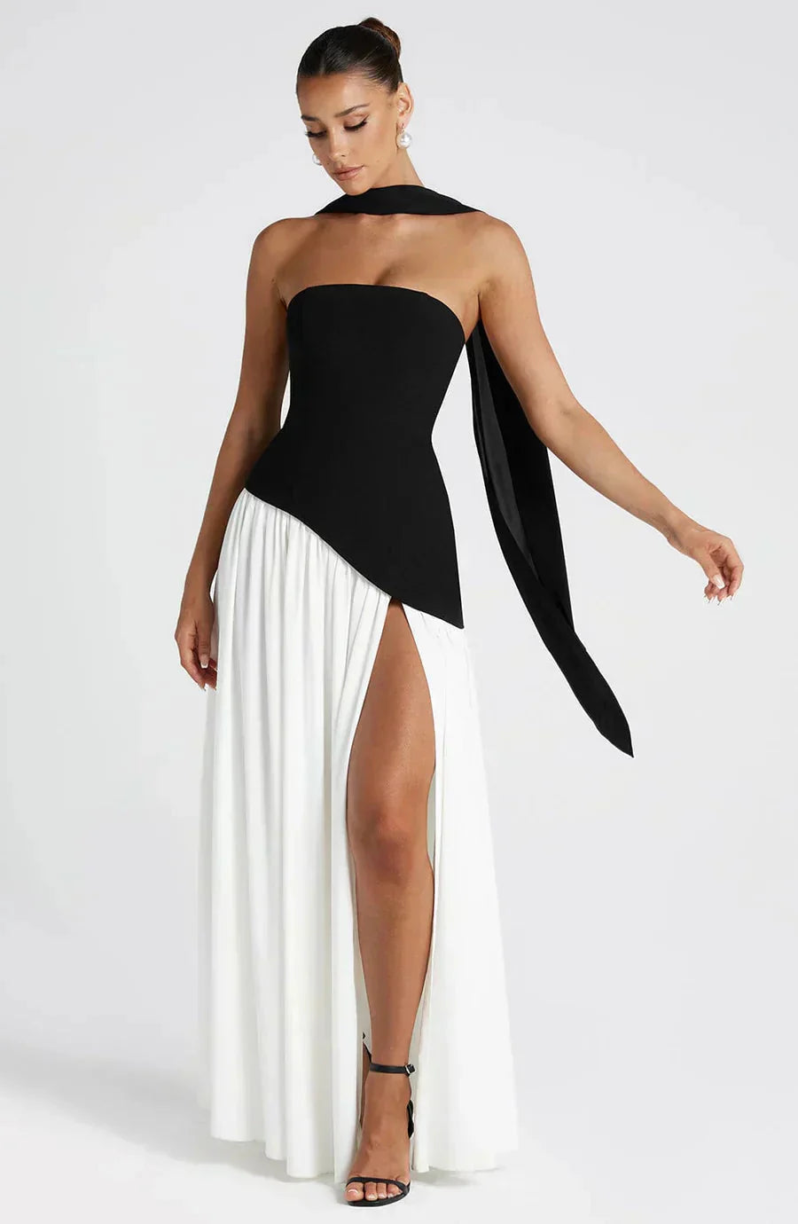 Un vestido sofisticado que combina el clásico blanco y negro con un diseño moderno y femenino. Perfecto para destacar con estilo en cualquier ocasión especial.